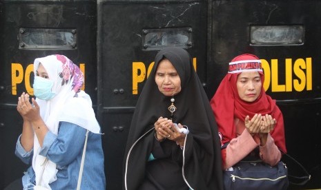 Sejumlah peserta aksi berdoa saat melakukan unjuk rasa di depan Gedung Bawaslu di Jalan MH Thamrin, Jakarta, Selasa (21/5/2019).