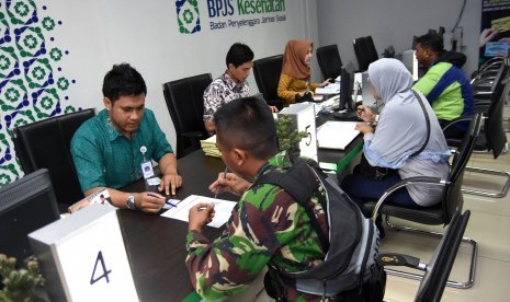  Sejumlah peserta antre untuk melakukan pendaftaran dan pembaruan data di Badan Penyelenggara Jaminan Sosial (BPJS) Kesehatan KCU Surabaya, Jawa Timur, Rabu (29/7). 