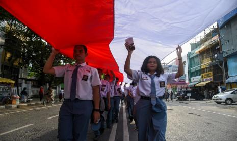 Sejumlah peserta membentangkan bendera merah putih di kawasan Jalan Brigjend Katamso, Medan, Sumatera Utara, Selasa (13/9/2022). Acara Kirab Merah Putih yang diikuti oleh para pelajar, mahasiswa, ormas, pemuda, TNI, Polri dengan membentangkan bendera merah putih sepanjang 150 meter tersebut mengusung tema menjaga keharmonisan dan menjunjung tinggi toleransi. 