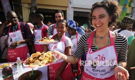 Sejumlah peserta membuat rujak uleg dengan memakai kostum unik saat Festival Rujak Uleg di kawasan Kembang Jepun, Surabaya, Jawa Timur. Festival Rujak Uleg menjadi momentum untuk menghidupkan kota tua di Surabaya.