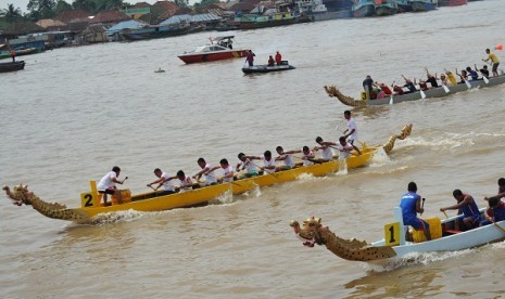 Sejumlah peserta mengayuh perahu naga pada etape akhir balap perahu naga yang merupakan rangkaian akhir dari Musi Triboatton 2012 di Benteng Kuto Besak Palembang, Sabtu (1/12). 