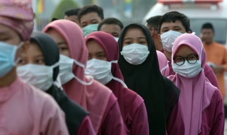 Sejumlah peserta upacara peringatan HUT ke-62 Provinsi Riau mengenakan masker medis akibat asap menyelimuti Kota Pekanbaru, Jumat (9/8/2019).