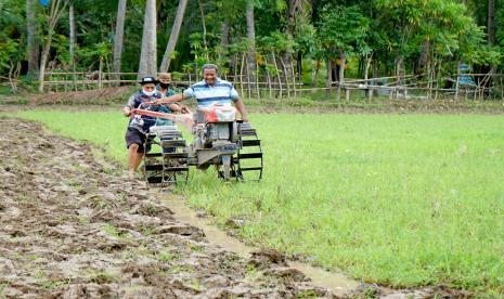 Sejumlah petani membajak sawah sebelum ditanami bibit padi di Desa Bulota, Kabupaten Gorontalo, Gorontalo, Jumat (25/3/2022). Guru besar IPB University Prof Dwi Andreas Santosa meminta pemerintah mewaspadai tren produksi padi nasional yang menurun pada masa periode fenomena alam La Nina dibandingkan dengan produksi padi pada periode yang sama beberapa tahun sebelumnya.