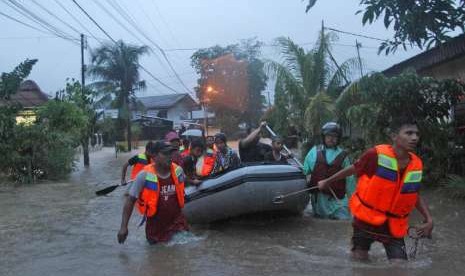 Sejumlah petugas Badan Penanggulangan Bencana Daerah (BPBD) mengevakuasi warga yang terimbas banjir di daerah Jondul Rawang Barat, Padang, Sumatera Barat, Rabu (26/9). 