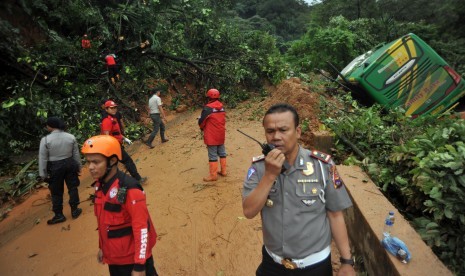 Sejumlah petugas berada di lokasi longsor yang menghantam tiga unit kendaraan, di Jalur Lintas Padang - Jambi, Panorama II Sitinjau Lauik, Padang, Sumatera Barat, Jumat (14/12/2018). 