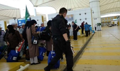 Sejumlah petugas berseragam nampak mengawasi jamaah haji Cina di Bandara Kingabdulaziz, Jeddah, Kamis (30/1). Tanpa emblem kesatuan dan hanya dilengkapi badge bendera Cina, mereka mengawal para jamaah hingga ke pesawat.