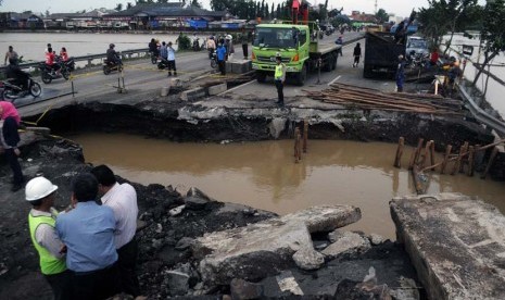 Sejumlah petugas Bina Marga dan Dinas Pekerjaan Umum Cirebon memantau jalur Pantura yang ambles di Desa Mandalawangi, Ciasem, Subang, Jawa Barat, Rabu (22/1).  (Antara/Novrian Arbi)