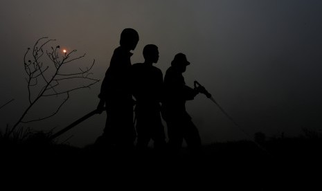 Sejumlah petugas BPBD Propinsi Sumatra Selatan dibantu anggota TNI AD memadamkan kebakaran lahan di Desa Sungai Rambutan, Kecamatan Indralaya Utara, Ogan Ilir (OI), Sumsel. Jumat (9/10). 