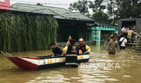 Sejumlah petugas dan relawan mengevakuasi warga dari Perumahan Griya Mukti yang terendam banjir di Jalan PM Noor, Samarinda, Kalimantan Timur, Selasa (11/6). Sekretaris Kota Samarinda Sugeng Chairuddin menyatakan banjir di Kota Samarinda yang terjadi sejak H+3 lebaran tersebut semakin meluas hingga meliputi tiga kecamatan yaitu Samarinda Utara, Samarinda Ulu dan Sungai Pinang. 