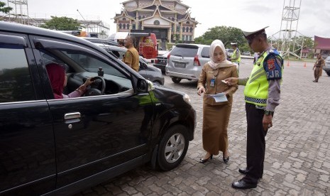 Sejumlah petugas dari Tim Pembina Samsat Provinsi Riau memeriksa pajak kendaraan warga saat operasi penertiban pajak kendaraan di Kota Pekanbaru, Selasa (16/10/2018). 