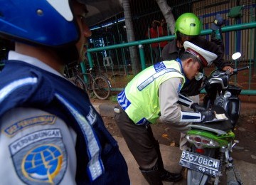 Sejumlah petugas Dinas Perhubungan Jakarta Barat mengembok ratusan sepada motor yang parkir liar saat menggelar razia parkir di depan Harco Glodok , Jakarta Barat, Selasa (28/2). (Republika/Prayogi)