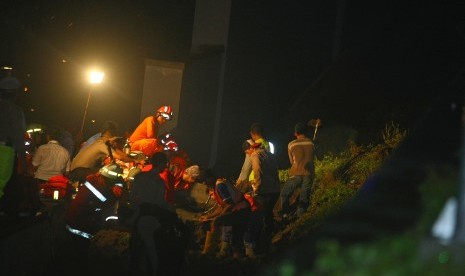 Sejumlah petugas gabungan dari badan SAR, TNI, Kepolisian dan Pemadam Kebakaran Bandara Soetta melakukan evakuasi terhadap korban longsor tembok under pass perlintasan Kereta Bandara Soetta di kawasan Parimeter Selatan, Bandara Soekarno Hatta, Tangerang, Banten, Senin (5/2) malam. 