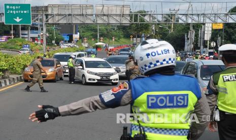 Sejumlah petugas gabungan dari Polres Bogor, Satpol PP dan Dishub Kabupaten Bogor melakukan pemeriksaan kendaraan di Check Pont Pembatasan Sosial Berskala Besar (PSBB), Simpang Gadog, Ciawi, Kabupaten Bogor, Jawa Barat, Rabu (27/5/2020). Kendaraan roda empat maupun dua yang melanggar aturan kebijakan PSBB Kabupaten Bogor di jalur wisata Puncak tersebut akan diputar balik kembali menuju Jakarta. 