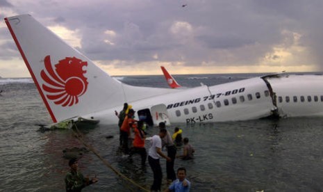  Sejumlah petugas gabungan melakukan evakuasi barang dan penumpang pesawat Lion Air rute Bandung-Denpasar yang tergelincir ke laut setelah berusaha mendarat di Bandara Ngurah Rai, Denpasar, Bali, Sabtu (13/4).