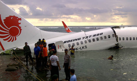 Sejumlah petugas gabungan melakukan evakuasi barang dan penumpang pesawat Lion Air yang tergelincir ke laut setelah berusaha mendarat di Bandara Ngurah Rai Denpasar, Bali, Sabtu (13/4/2013)