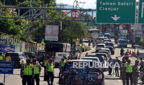 Sejumlah petugas gabungan melakukan operasi razia penggunaan masker dan pemeriksaan surat hasil tes cepat antigen di Simpang Gadog, Kabupaten Bogor, Jawa Barat, Kamis (24/12/2020). Pemerintah Kabupaten Bogor mewajibkan para wisatawan yang hendak berkunjung ke tempat wisata di kawasan Kabupaten Bogor maupun menginap di hotel, resort, atau cottage untuk menunjukkan hasil tes cepat antigen sebagai upaya mencegah penyebaran COVID-19 di saat libur Natal dan Tahun Baru.