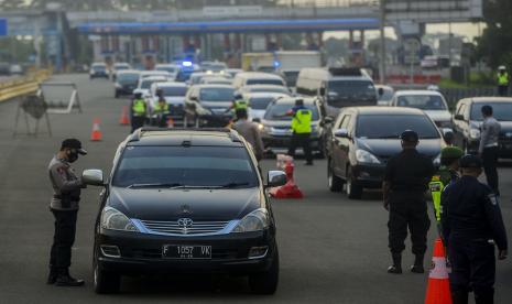 Sejumlah petugas gabungan memeriksa mobil yang keluar dari Gerbang Tol Bogor saat melakukan penyekatan di Bogor, Jawa Barat.