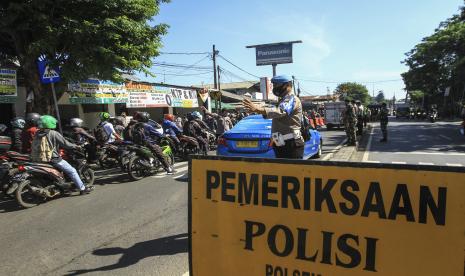 Sejumlah petugas gabungan Polisi, TNI dan Satpol PP berjaga saat melakukan filterisasi kendaraan massa aksi di Jalan Raya Bogor, Depok - Jakarta, Kamis (2/11/2021). Polda Metro Jaya melakukan filterisasi kendaraan arah Jakarta di sejumlah titik perbatasan mencegah massa aksi Reuni 212. 