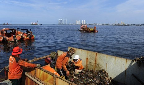 Sejumlah petugas kebersihan memindahkan sampah dari kapal ke truk pengangkut sampah 