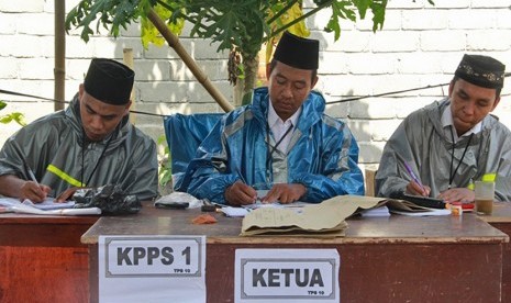 Sejumlah petugas Kelompok Panitia Pemungutan Suara (KPPS) mengenakan jas hujan saat pemungutan suara Pilkada serentak 2015 Walikota dan Wakil Walikota Mataram di Tempat Pemungutan Suara (TPS) 10, Lingkungan Kebon Jaya Timur, Kelurahan Monjok, Kecamatan Sel