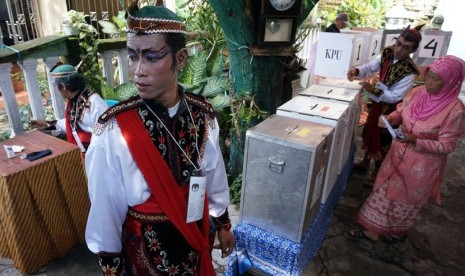   Sejumlah petugas Kelompok Penyelenggara Pemungutan Suara (KPPS) memakai kostum penari Remo khas Surabaya, di TPS 03, Tegalsari Surabaya, Rabu (9/4). (Antara/Eric Ireng)