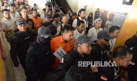 Sejumlah petugas kepolisian bersama tersangka saat reka ulang adegan kasus peluru nyasar di Lapangan Tembak, Senayan, Jakarta Selatan, Jumat (19/10). Dua tersangka berinisial IAW dan RMY dihadirkan untuk memperagakan 25 adegan selama rekonstruksi kasus peluru nyasar yang terjadi di Gedung DPR/MPR pada Senin (15/10). 