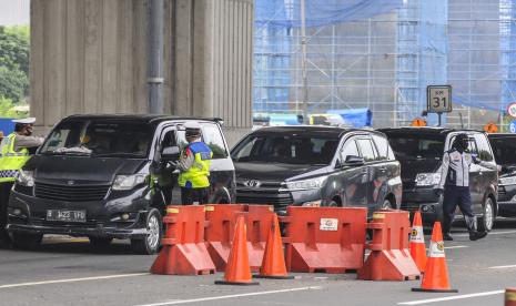 Sejumlah petugas kepolisian memeriksa kendaran pribadi yang melintas di tol Jakarta-Cikampek di Cikarang Barat, Kabupaten Bekasi, Jawa Barat, Sabtu (2/5/2020). Menurut data Ditlantas Polda Metro Jaya, sebanyak 7.748 kendaraan dipaksa putar balik menuju lokasi asal akibat terjaring razia Operasi Ketupat 2020.