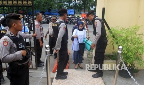 Sejumlah petugas kepolisian memeriksa tas warga yang akan masuk ke Polresta Padang, Sumatera Barat, Rabu (13/11/2019). 