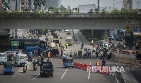 Sejumlah petugas melakukan pelaksanaan uji coba pengaturan dan rekayasa lalu lintas di simpang Matraman, Jakarta, Kamis (20/7).