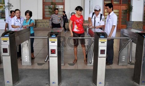   Sejumlah petugas membantu calon penumpang kereta api listrik (KRL) menggunakan tiket elektronik (e-ticketing) di Stasiun Jakarta Kota, Selasa (23/4).    (Republika/Prayogi)