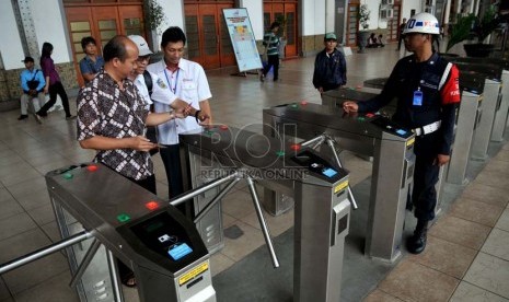   Sejumlah petugas membantu calon penumpang kereta api listrik (KRL) menggunakan tiket elektronik (e-ticketing) di Stasiun Jakarta Kota, Selasa (23/4).    (Republika/Prayogi)