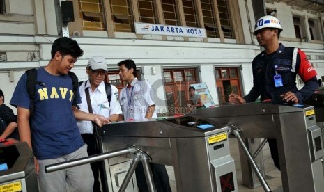 Petugas membantu calon penumpang kereta api listrik (KRL) menggunakan tiket elektronik (e-ticketing) di Stasiun Jakarta Kota, Selasa (23/4).    (Republika/Prayogi)