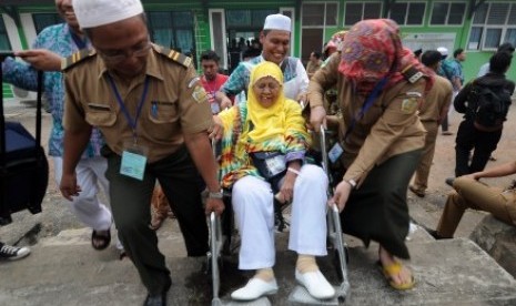 petugas haji membantu seorang jamaah  