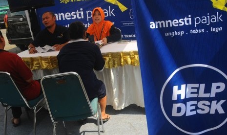 Sejumlah petugas memberikan sosialisasi Amnesti Pajak kepada pedagang di Pasar Sunggingan, Boyolali, Jawa Tengah, Senin (28/11). 