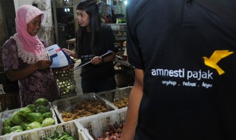 Sejumlah petugas memberikan sosialisasi Amnesti Pajak kepada pedagang di Pasar Sunggingan, Boyolali, Jawa Tengah, Senin (28/11).