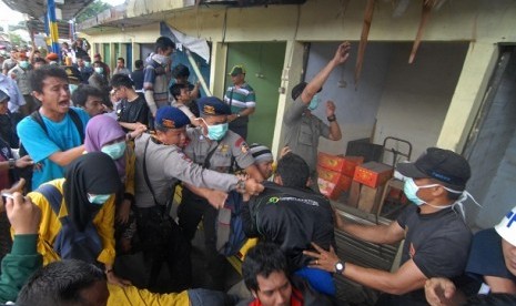 Sejumlah Petugas membongkar sejumlah kios pedagang kaki lima (PKL) di Stasiun Lenteng Agung, Jakarta Selatan, Ahad (30/12). Meskipun proses penertiban ini sempat ricuh karena sejumlah mahasiswa mengajak berdialog namun proses penertiban tetap dilakukan gun