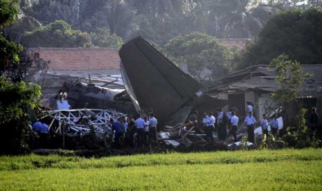 Sejumlah Petugas mengamankan bangkai pesawat Fokker 27 yang terjatuh di komplek Rajawali, Lapangan Udara Halim Perdana Kusuma, Jakarta, Kamis (21/6).