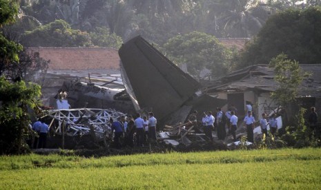    Sejumlah Petugas mengamankan bangkai pesawat Fokker 27 yang jatuh di komplek Rajawali, Lapangan Udara Halim Perdana Kusuma, Jakarta, Kamis (21/6).  (Adhi Wicaksono/Republika)