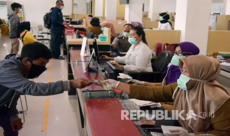 Petugas mengenakan masker dan sarung tangan saat melayani wajib pajak (Ilustrasi). Tangerang beri keringanan pembayaran pajak daerah.