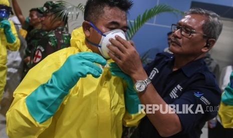 Sejumlah petugas mengenakan pakaian pelindung lengkap saat bersiap menyambut kedatangan kru kapal pesiar Diamond Princess yang dinyatakan negatif virus corona di Bandara Kertajati, Kabupaten Majalengka, Jawa Barat, Ahad (1/3/2020).