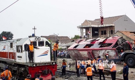 Sejumlah petugas mengevakuasi bus yang tertabrak kereta api Argo Parahyangan KA-32 jurusan Gambir - Bandung di Warung Bambu, Karawang, Jawa Barat, Senin (26/08/2019). Kecelakaan tersebut terjadi akibat bus dengan nomor polisi T 7915 DC mogok di tengah perlintasan kereta api. 