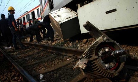   Sejumlah petugas mengevakuasi gerbong KRL Commuter Line Jurusan Bogor-Jakarta Kota yang anjlok dan menabrak pembatas rel di Stasiun Cilebut, Bogor,Kamis (4/10).