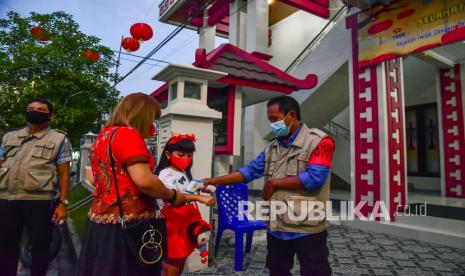 Sejumlah petugas mengukur suhu badan jemaat yang akan mengikuti kebaktian syukur akhir Tahun Imlek 2572 di Gereja Protestan Maluku (GPM) Hok Im Tong Ambon, Provinsi Maluku, Senin (31/1/2022). Warga kristen tionghoa di Ambon menyambut Imlek 2572 secara sederhana dengan kebaktian yang menerapkan protokol kesehatan, untuk mencegah penyebaran COVID-19. 