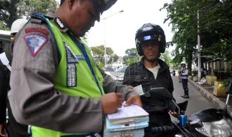  Sejumlah petugas menindak salah seorang pengendara dalam Operasi Gabungan Zebra jaya 2013 di Jalan Otto Iskandardinata, Jakarta Timur, Kamis (28/11).  (Republika/Rakhmawaty La'lang)