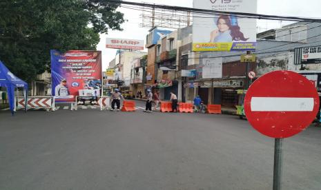 Sejumlah petugas menutup kawasan pusat pertokoan Jalan HZ Mustofa dari arah Taman Kota Tasikmalaya, Ahad (26/4). 