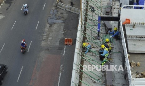 Sejumlah petugas menyelesaikan proyek pembangunan moda transportasi massal, Mass Rapid Transit (MRT) di Jalan Kyai Maja, Jakarta Selatan, Ahad (9/7).