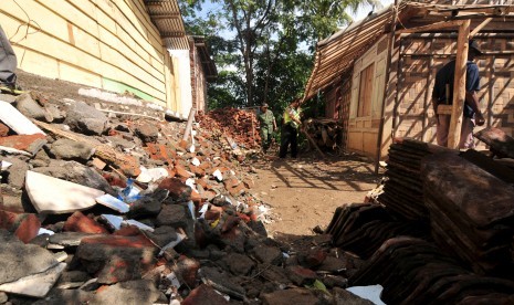 Sejumlah petugas menyingkirkan puing-puing rumah yang longsor di Desa Dermasuci, Kabupaten Tegal, Jawa Tengah, Selasa (23/2)