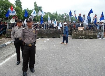 Sejumlah polisi bersiaga di gerbang kamp Chevron Pasific Indonesia (CPI) yang diblokir ratusan buruh di Pekanbaru. Para buruh memblokir gerbang kamp Chevron selama dua hari untuk mendesak perbaikan kontrak yang melindungi hak-hak buruh subkontraktor.