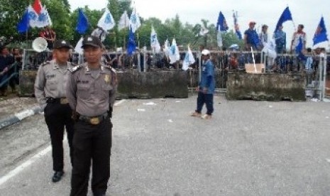 Sejumlah petugas polisi bersiaga di gerbang kamp Chevron Pasific Indonesia (CPI) yang diblokir ratusan buruh di Pekanbaru. Para buruh memblokir gerbang kamp Chevron selama dua hari untuk mendesak perbaikan kontrak yang melindungi hak-hak buruh subkontrakto