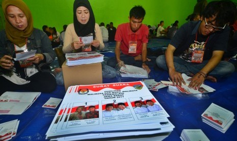 Sejumlah petugas PPK dan PPS menyelesaikan pekerjaan melipat surat suara Pilkada Serentak di Aula Gedung Graha Transisto, Kampung Cikanyere, Kota Tasikmalaya, Jawa Barat, Selasa (17/1).